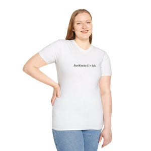 Puede incluir: Camiseta blanca con el texto "Awkward > Ick" en negro. La camiseta la lleva una persona con vaqueros azules.