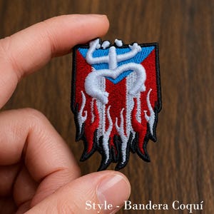May include: Embroidered patch featuring the Puerto Rican flag design with a stylized coqui frog symbol. The patch has a red, white, and blue color scheme with a black border. The text "Style - Bandera Coquí" is at the bottom.