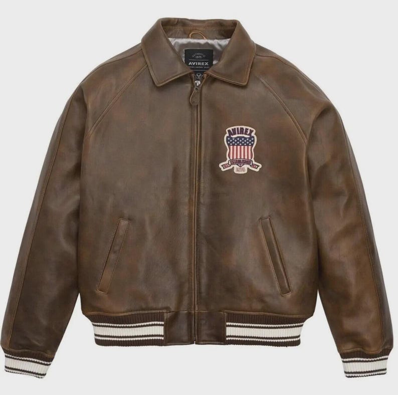 May include: A white ceramic mug with a black handle and the text "But First, Coffee" in a bold, black font. The mug is set against a blurred background, suggesting a cozy setting.