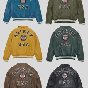May include: A collection of six leather bomber jackets in various colors: blue, olive green, mustard yellow, dark green, brown, and black. Each jacket features the "AVIREX" logo and "USA" text on the back, with a striped collar and cuffs.