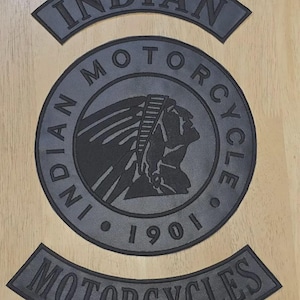 May include: A set of three black embroidered patches featuring the Indian Motorcycle logo. The central circular patch displays a profile of a person wearing a headdress with the text Indian Motorcycle 1901. Two curved rocker patches accompany it.