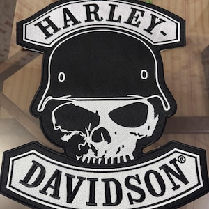 Puede incluir: Un parche bordado en blanco y negro con el texto HARLEY en la parte superior y DAVIDSON en la inferior. El diseño central muestra una calavera blanca con un casco negro de contornos blancos, sobre un fondo negro.