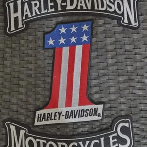 Puede incluir: Un conjunto de tres parches bordados que incluye un rocker negro y blanco de Harley-Davidson, un parche central con el número uno y un diseño de bandera estadounidense en rojo, blanco y azul, y un rocker de Harley-Davidson Motorcycles en negro y blanco.