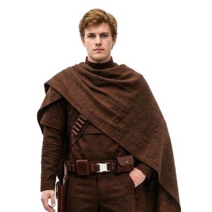 May include: A brown costume comprising a long-sleeved shirt, trousers, and a cape. The outfit includes a belt with pouches and a holster. The boots are brown. The costume has a futuristic or fantasy theme.