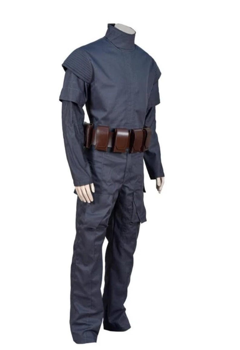 May include: A dark blue costume with a high collar, shoulder pads, and long sleeves. The outfit includes matching pants and a brown belt with multiple pouches. The costume is displayed on a mannequin against a white background.