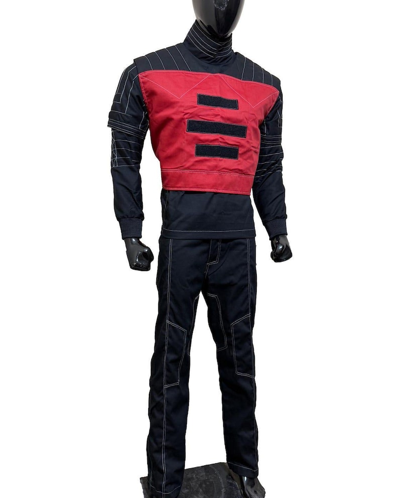 May include: A black and red outfit displayed on a mannequin. The outfit includes a black turtleneck, a red vest with three horizontal black stripes, black pants, and white stitching details. The outfit is designed with a futuristic aesthetic.