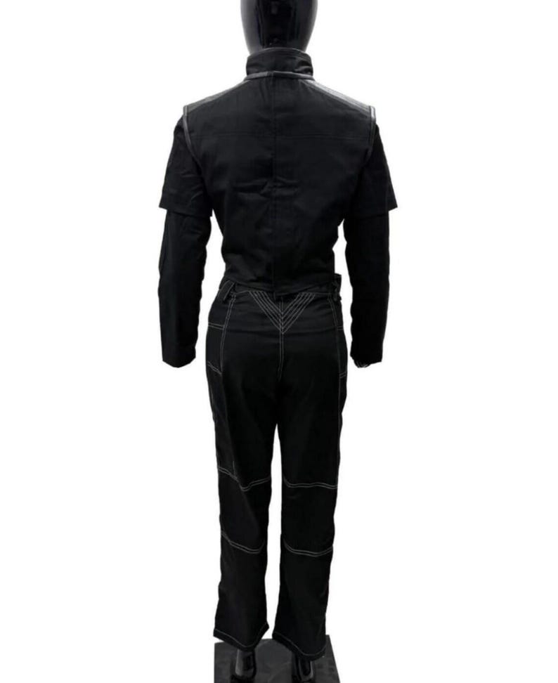 Puede incluir: Mono negro con detalles de costura blancos. El mono presenta un cuello, mangas cortas y mangas largas debajo. Los pantalones tienen parches en las rodillas y un dise&ntilde;o en forma de V en la espalda. La prenda se exhibe en un maniqu&iacute;.