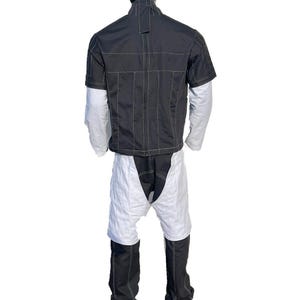 May include: A black and white outfit featuring a short-sleeved jacket over a long-sleeved shirt, paired with shorts and pants. The jacket and pants have visible stitching. The outfit is designed with a unique, modern aesthetic.