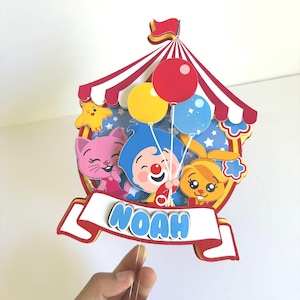 May include: A white ceramic mug with a black handle and the text "But First, Coffee" in a bold, black font. The mug is filled with a dark liquid, likely coffee, and sits on a light-colored surface.