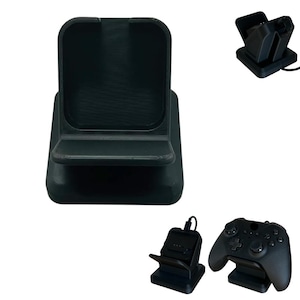 Puede incluir: Base de carga negra para mando de juegos. La base tiene una base rectangular con una parte delantera curvada y una cuna para sujetar el mando. Imágenes adicionales muestran un mando y accesorios de carga.