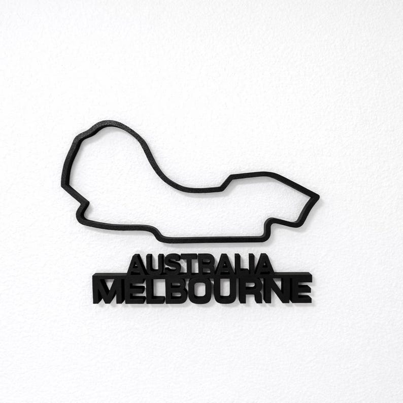May include: A black wall-mounted sign featuring the outline of the Melbourne Grand Prix Circuit in Australia. The design includes the track layout as a continuous line above the bold, capitalized text that reads AUSTRALIA MELBOURNE.