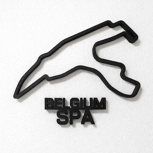May include: A black, three-dimensional wall-mounted sculpture depicting the layout of the Spa-Francorchamps racetrack in Belgium. Below the track outline, the words BELGIUM and SPA are displayed in bold, black, block-style capital letters.