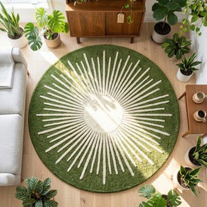 May include: Overhead view of a round green rug with a white sunburst design. The rug is surrounded by potted plants, a wooden cabinet, and a light-colored sofa. The rug is a decorative element for a living room.