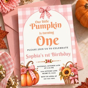 Puede incluir: Una tarjeta de invitación de cumpleaños rectangular con borde de cuadros vichy rosa y blanco, marco arqueado con lazo rosa y el texto Our little Pumpkin is turning One. Incluye una ilustración de calabaza, cesta de flores y detalles.