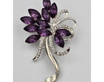 Elegante broche de diamantes de imitación color púrpura con forma de marquesa y diseño floral en tono plateado.