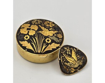 Broche vintage de damasquinado con forma de pastillero, color oro, pájaro negro y estampado floral.