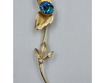 Broche floral vintage en tono dorado con cristal artístico iridiscente azul verdoso.