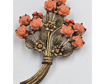 Broche vintage dorado con ramo floral y rosas naranjas talladas.
