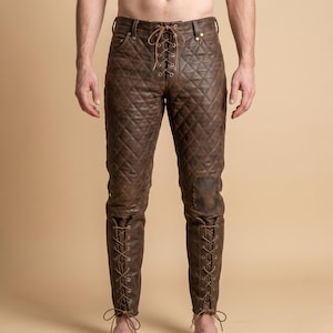 May include: Dark brown leather pants featuring a quilted diamond pattern throughout the legs. The front closure includes a lace-up design with metal eyelets and thin leather cords. Additional lace-up details are present at the lower calves.