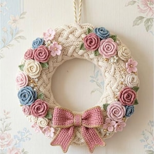 May include: A cream-colored, knitted wreath adorned with crochet roses in shades of pink, blue, and cream, accented with small pearl beads and a pink bow. The wreath is suspended by a beige cord, perfect for home decor.