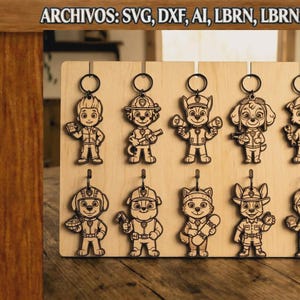 Puede incluir: Un tablero de madera clara con diez llaveros de madera cortados con láser en forma de personajes de dibujos animados. El texto en la parte superior dice ARCHIVOS: SVG, DXF, AI, LBRN, LBRN2, PDF. Cada llavero está unido a una anilla de metal.