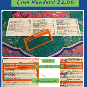 May include: Image of a lottery ticket with printed numbers and an orange rectangular cutout. The text "Line Readers $2.00" is at the top. The ticket has various number combinations and instructions.