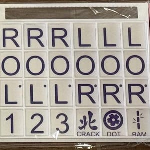 May include: A set of white tiles with dark blue letters and symbols. The tiles include the letters R, L, and O, along with the numbers 1, 2, and 3. The set also features the words CRACK, DOT, and BAM.