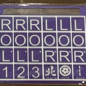 May include: A purple and white tile game board with letters and numbers. The board has a grid of squares with white letters and numbers on a purple background. The text "CRACK DOT RAM" is visible.