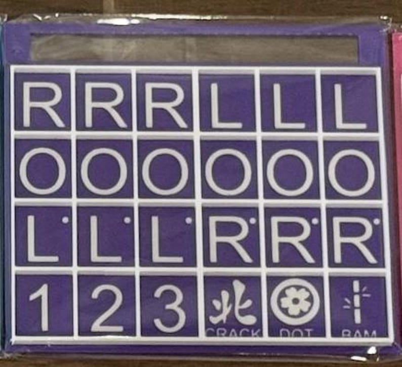 May include: A purple and white tile game board with letters and numbers. The board has a grid of squares with white letters and numbers on a purple background. The text "CRACK DOT RAM" is visible.