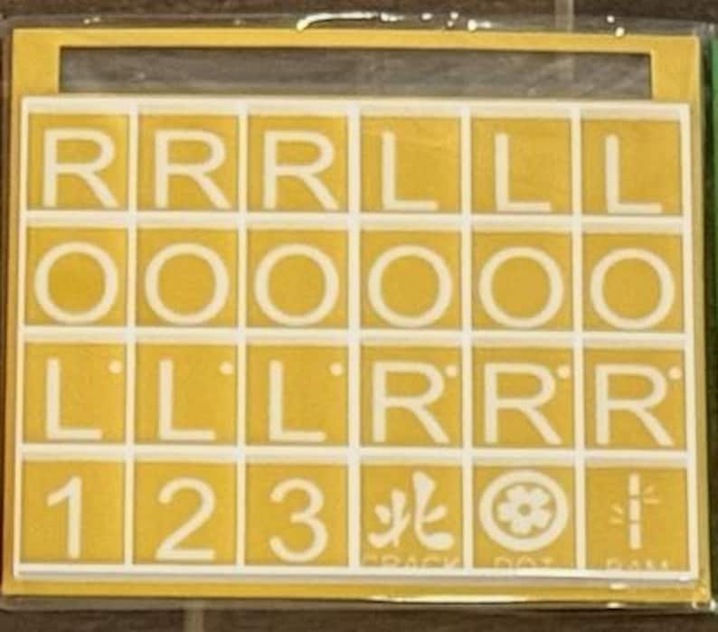 May include: A yellow and white tile set with letters and numbers. The tiles are arranged in a grid pattern, with letters like "R" and "L" and numbers "1", "2", and "3". The set also includes Japanese characters and symbols.