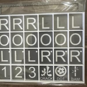 May include: A set of Scrabble tiles in a white grid. The tiles are gray with white letters and numbers. The letters include R, L, O, and the numbers 1, 2, and 3. Some tiles have Japanese characters and the words CRACK, DOT, and BAM.