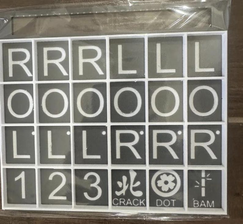 May include: A set of Scrabble tiles in a white grid. The tiles are gray with white letters and numbers. The letters include R, L, O, and the numbers 1, 2, and 3. Some tiles have Japanese characters and the words CRACK, DOT, and BAM.