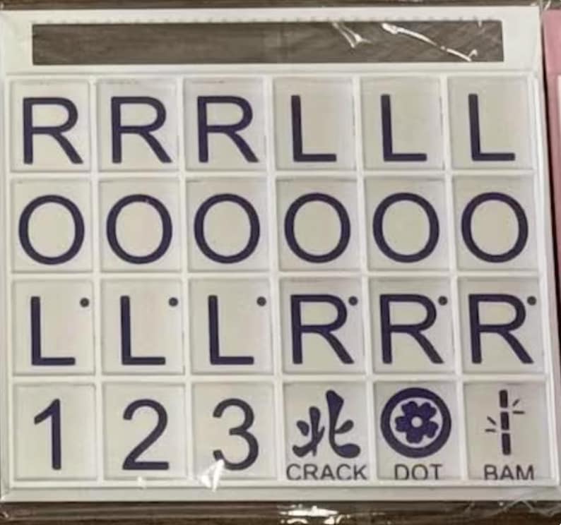May include: A set of white tiles with dark blue letters and symbols. The tiles display letters R, L, and O, along with numbers 1, 2, and 3. The words "CRACK", "DOT", and "BAM" are also present.