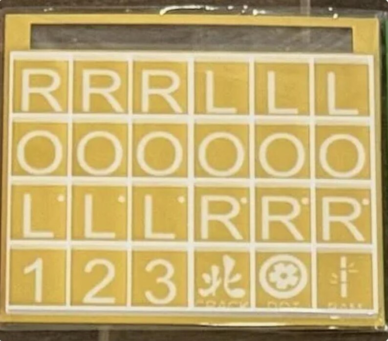May include: A yellow stencil with white letters and numbers. The letters include R, L, and O. Numbers 1, 2, and 3 are also present. Symbols and the text "CRACK DOT FAN" are included. The stencil is in a clear plastic case.