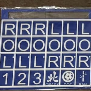 May include: A blue and white tile game board with letters and numbers. The board has white squares with the letters R, L, and O, and the numbers 1, 2, and 3. The board also has symbols and the words CRACK, DOT, and RAM.