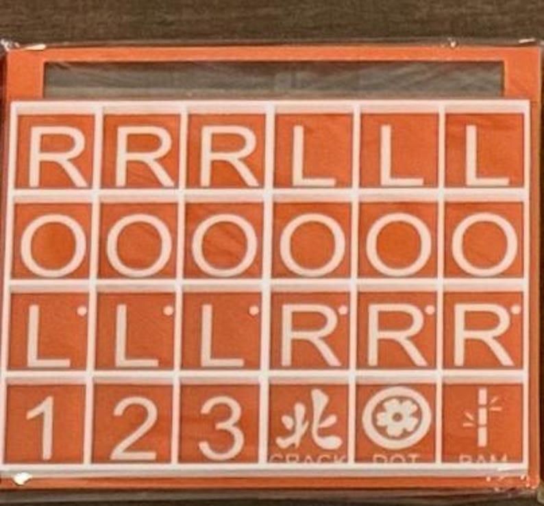 May include: An orange game board with white letter tiles spelling out "RRRLL OOOOO LLLRR 123". The game board also includes symbols and the text "CRACK DOT RAM".