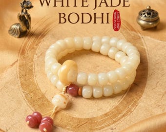 Puede incluir: Una pulsera de doble hebra hecha de cuentas lisas de color blanco hueso con un anillo amarillo central, una pequeña cuenta blanca tallada y dos cuentas colgantes de color rosa oscuro. Se ve el texto "WHITE JADE BODHI" y un sello rojo "DIRECT SHIP FROM PUTUO".