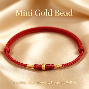 Puede incluir: Una pulsera de cordón rojo con una pequeña cuenta dorada en el centro, flanqueada por dos secciones de hilo dorado enrollado. El texto Mini Gold Bead y Everything Goes Smoothly, Prosperity Rolls In es visible arriba y abajo de la pulsera.