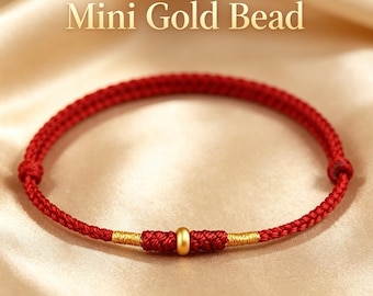 Puede incluir: Una pulsera de cordón rojo con una pequeña cuenta dorada en el centro, flanqueada por dos secciones de hilo dorado enrollado. El texto Mini Gold Bead y Everything Goes Smoothly, Prosperity Rolls In es visible arriba y abajo de la pulsera.
