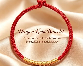 Puede incluir: Una pulsera de cordón rojo con un acento cilíndrico central texturizado de color dorado y un cierre de nudo. El texto Dragon Knot Bracelet, Protection & Luck: Invite Positive Energy, Keep Negativity Away está impreso en el centro.