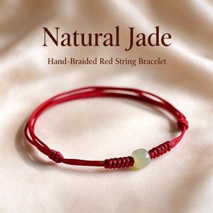 May include: A hand-braided red string bracelet featuring a single smooth, pale green jade bead. The text Natural Jade Hand-Braided Red String Bracelet is visible above the jewelry. The bracelet has adjustable knotted sections.