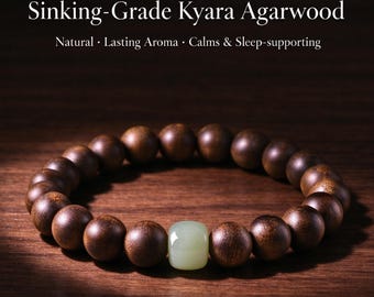 Puede incluir: Una pulsera hecha de cuentas de madera esféricas de color marrón oscuro y una cuenta rectangular de color verde pálido y lisa. El texto superior dice: Sinking-Grade Kyara Agarwood. Natural · Lasting Aroma · Calms & Sleep-supporting.