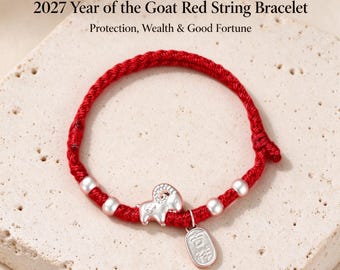 Puede incluir: Una pulsera de hilo rojo con un dije de cabra de plata, cuatro cuentas plateadas y una pequeña etiqueta rectangular de plata con caracteres chinos. El texto 2027 Year of the Goat Red String Bracelet es visible en la imagen.