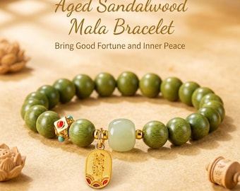 Puede incluir: Una pulsera hecha de cuentas redondas de madera de sándalo verde con una cuenta central de piedra verde pálido, un dije de metal dorado con detalles rojos y una pequeña cuenta cúbica dorada con incrustaciones rojas y turquesas.