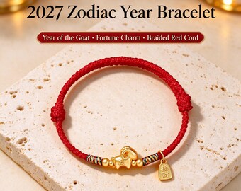 Puede incluir: Una pulsera de cordón trenzado rojo con un dije de cabra dorado, pequeñas cuentas doradas y un colgante rectangular dorado con caracteres chinos. El texto 2027 Zodiac Year Bracelet, Year of the Goat, Fortune Charm, Braided Red Cord y New Year luck begins on your wrist es visible.