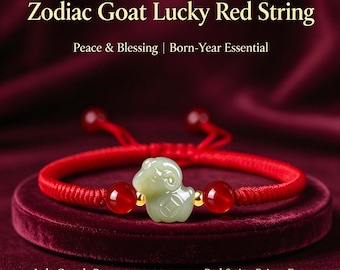 Puede incluir: Una pulsera de hilo rojo con un dije central de cabra tallado en jade verde pálido, flanqueado por dos pequeñas cuentas doradas y dos cuentas rojas translúcidas más grandes. El texto dice: Zodiac Goat Lucky Red String, Peace & Blessing, Born-Year Essential, Jade Guards Peace, Red String Brings Fortune.