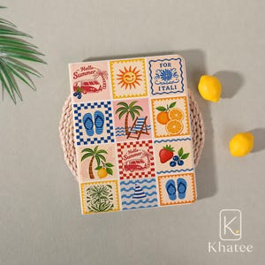 May include: A rectangular notebook featuring a grid of twelve colorful summer-themed illustrations, including a camper van, a sun, a beach chair, palm trees, flip-flops, citrus slices, a strawberry, blueberries, and text reading Hello Summer and FOR ITALI.