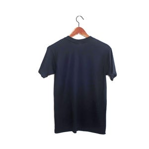 May include: A plain dark blue t-shirt hanging on a wooden hanger against a white background.