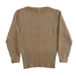 May include: A tan-colored sweater with a V-neck and long sleeves. The bottom hem and cuffs are ribbed. The sweater is made of a knitted material and is displayed against a white background.