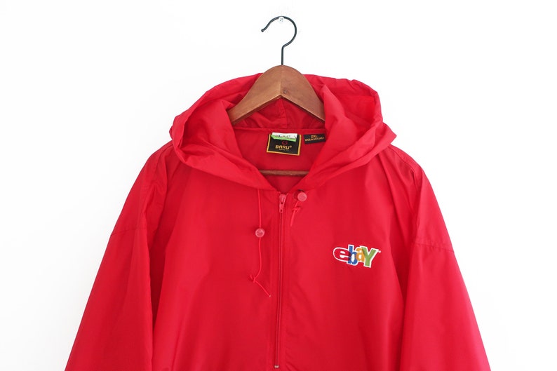 May include: Red hooded jacket with a zip fastening and the eBay logo embroidered on the front. The logo is in multi-coloured lettering.
